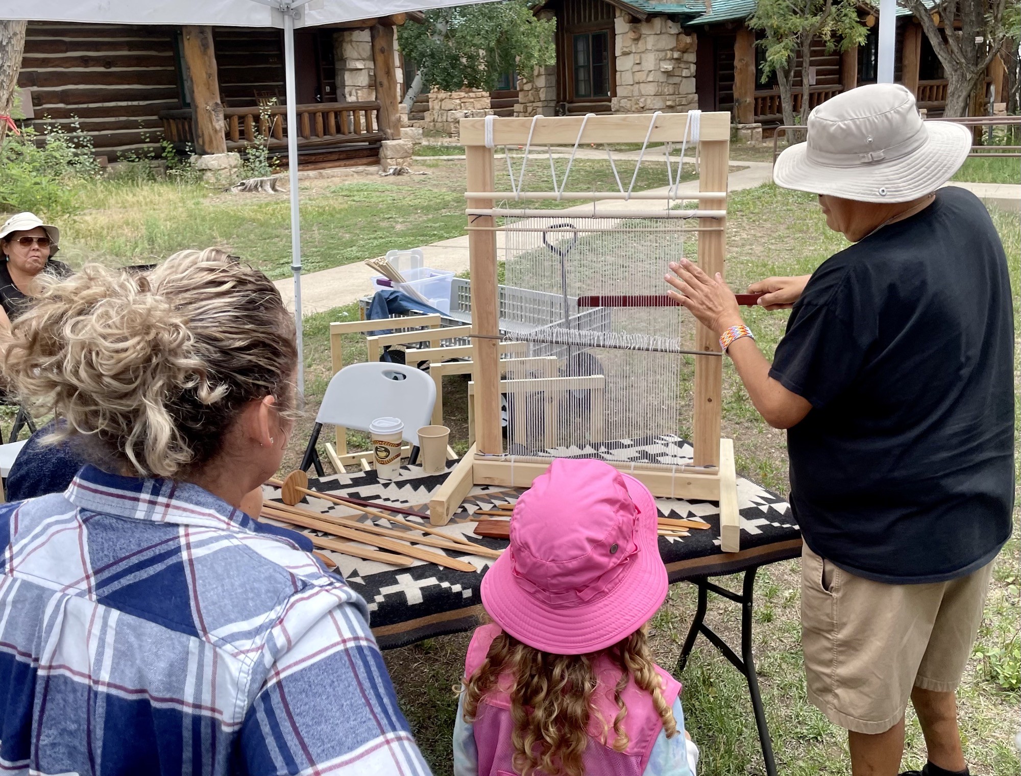Lyle Harvey shows visitors weaving techniques on a loom